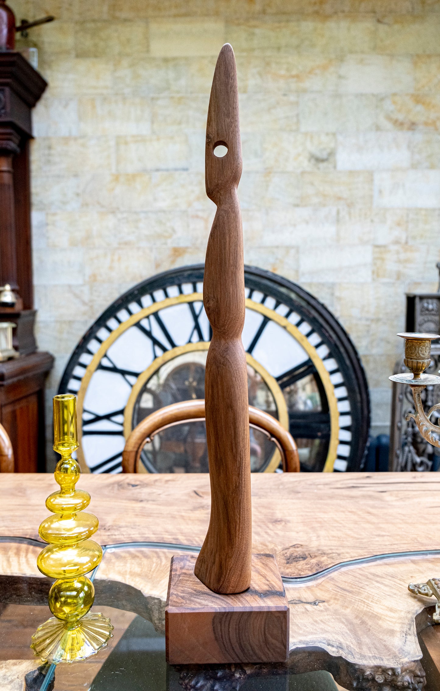 Meet 'The Visitor' - A Remarkable Live Edge Wood Sculpture. 'The Visitor' is an extraordinary handcrafted wooden sculpture, distinguished by its towering and gracefully slender design. Crafted from high-quality Black Walnut wood, this abstract Live Edge artwork unveils exceptional grain patterns and an exquisite delicacy sure to captivate all who behold it. Standing proudly at a height of 85cm atop a 15cm square base, this sculpture represents a truly original and organic wood masterpiece.