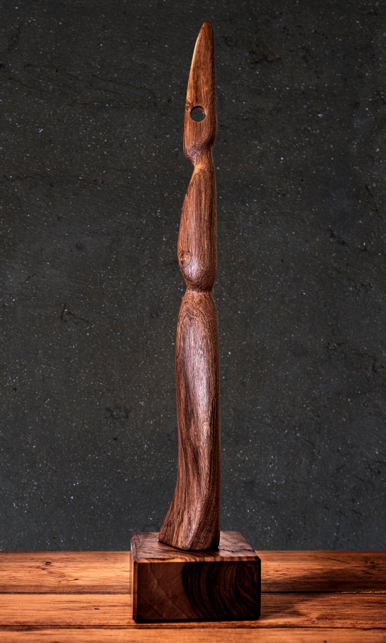 Original wood sculpture. Live Edge Sculpture The Visitor. The Visitor is a remarkable Live Edge handmade wood sculpture that stands tall and boasts an elegant, slender design. The figurine is crafted from Black Walnut high quality wood and this abstract Live Edge wood art showcases exceptional grain patterns and a delicate aesthetic that is sure to captivate anyone who sees it. This natural and organic sculpture stands at 85cm tall on a 15cm square base.