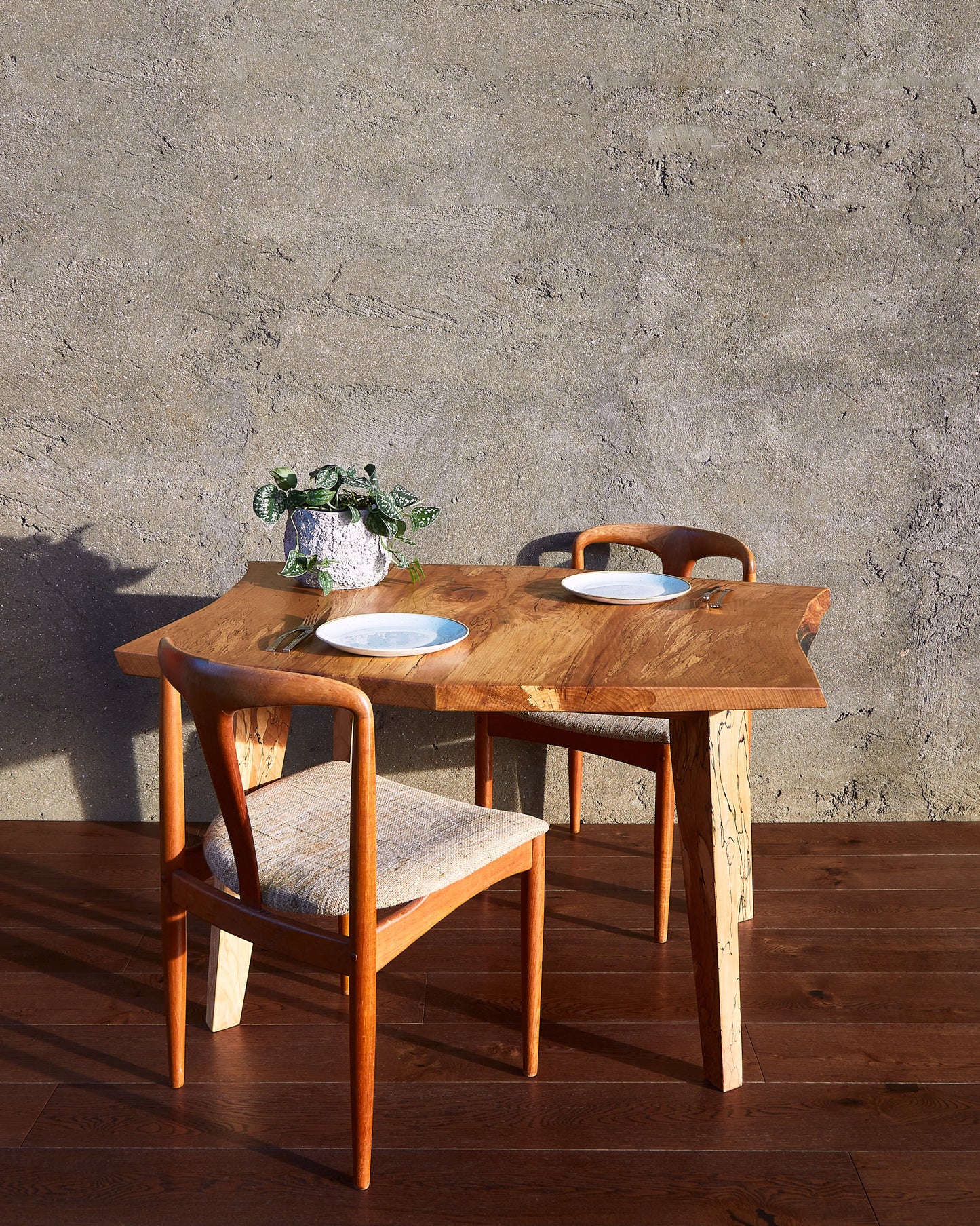 The Moff Dining Table stands as a striking example of Live Edge functional art. Crafted from spalted beech, this natural edge table boasts an intricately detailed pattern that is truly exceptional. The fusion of mid-century modern legs with the beautifully book-matched tabletop infuses this solid wood dining table with abundant character. A final touch of natural wax finish gives it a lustrous, enchanting glow. Expect this table to take center stage in any room and provide years of enjoyment.