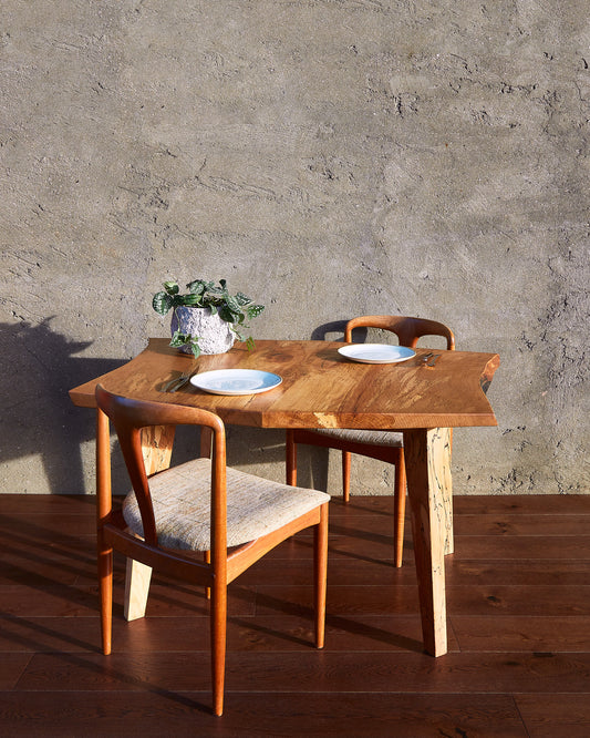 The Moff Dining Table stands as a striking example of Live Edge functional art. Crafted from spalted beech, this natural edge table boasts an intricately detailed pattern that is truly exceptional. The fusion of mid-century modern legs with the beautifully book-matched tabletop infuses this solid wood dining table with abundant character. A final touch of natural wax finish gives it a lustrous, enchanting glow. Expect this table to take center stage in any room and provide years of enjoyment.