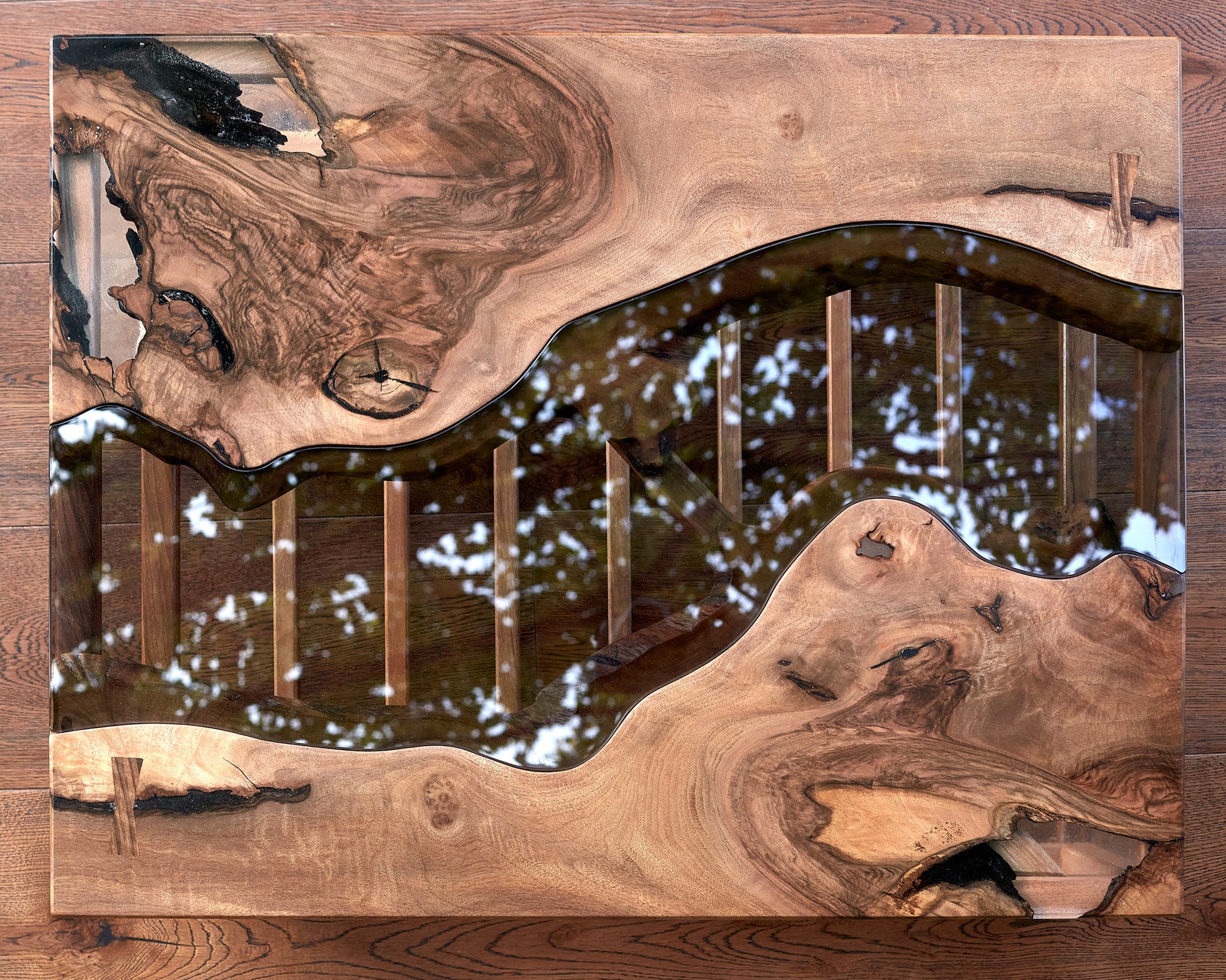 Unveil The Narva River Table, a spectacular Live Edge river table meticulously fashioned from Black Walnut wood by the skilled artisans at Live Edge Tables. This wood is celebrated for its unparalleled strength and durability, guaranteeing that this table boasts the utmost quality. Its contemporary design, highlighted by a natural raw edge, effortlessly harmonizes with any home decor. The wood's breathtaking beauty and the flawless craftsmanship combine to create an indelible and lasting impression.