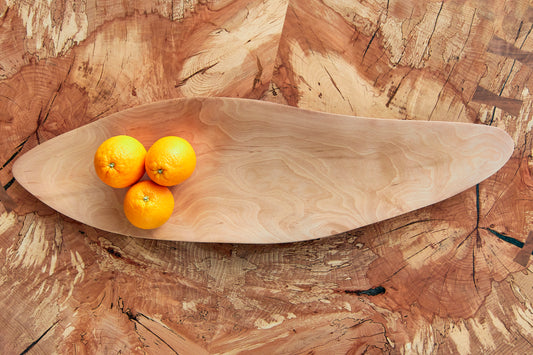 Live Edge Fruit Dish, Beech Wood Accent. Introducing our stylish and sleek Live Edge fruit dish, crafted from the finest Ash wood. Its slimline design creates a striking focal point for your table. The natural beauty of the Live Edge and the Ash wood's unique grain patterns adds a touch of sophistication to any home. Perfect for showcasing your favourite fruits and impressing your guests. The fruit bowl is 80cm in length, 20cm in width and 3cm deep, it has a long and slender oblong design with curved edges.