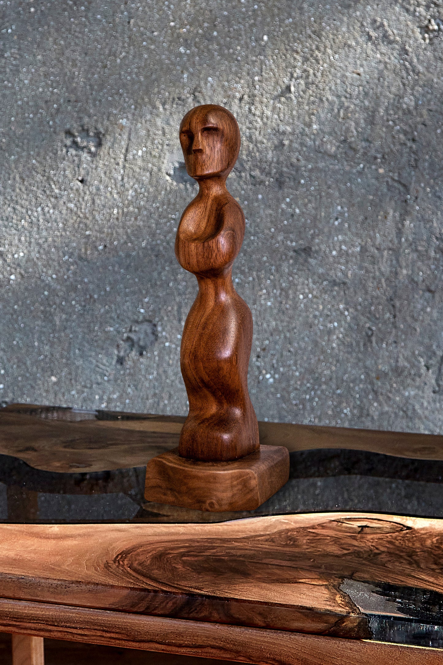 Experience the Elegance of 'Iroko Prayer' with Our Live Edge Sculpture. This captivating wooden statue is a true work of art, meticulously handcrafted to grace your home with its presence. Fashioned from the exquisite Iroko wood, renowned for its healing properties, this remarkable sculpture showcases a beautifully hand-carved wooden figurine, elegantly mounted on a sleek black walnut raw edge plinth. It's a truly original wood sculpture that adds a touch of timeless beauty to any space.