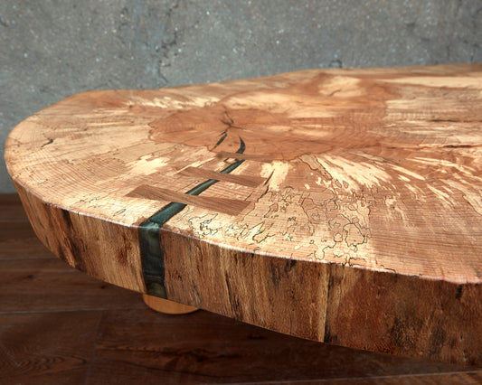 Live Edge Tables Cocoon Coffee Table. The grain of the spalted beech Live Edge wood shines through on this organic and rustic coffee table. creating a stunning highlight of the interior. As practical as it is stylish the solid wood slab table features a detailed pattern achieved by the book-matching technique of joinery. Its natural raw edge makes it a unique piece of furniture. The smooth tabletop rests on three cylindrical solid wooden legs creating a perfect flow and balance. 