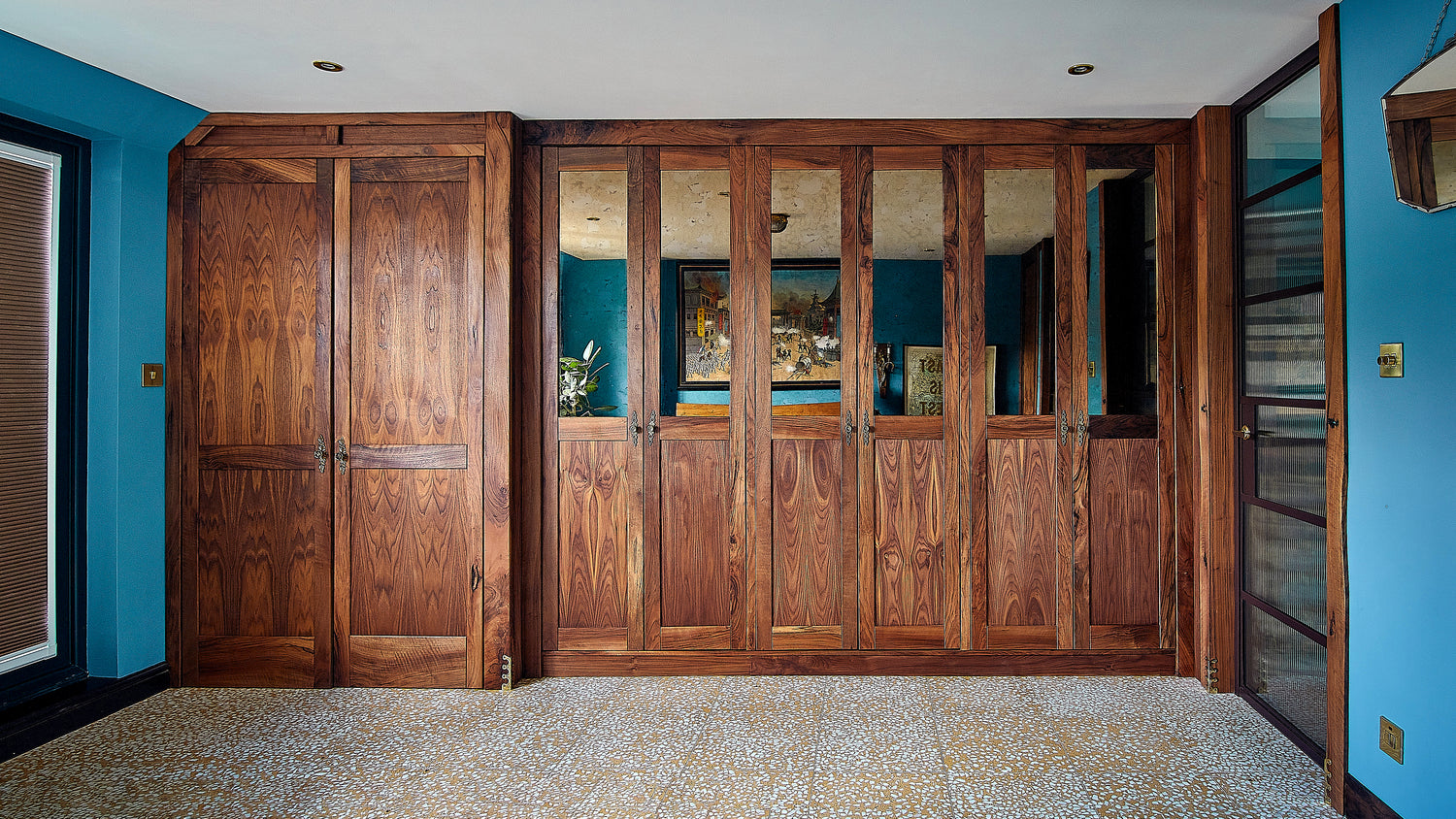 Live Edge Creations presents a luxurious and stylish fitted wardrobe crafted in black walnut wood, exuding sophistication and elegance. With ample space to store your clothing, the stylish wardrobe enhances the room's appeal with mirrored doors and Black Walnut accents.